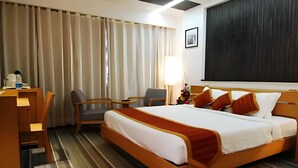 A hotel room with a bed, a desk, a chair, a lamp, and a picture on the wall. - Onn Hotel (Ludhiana)