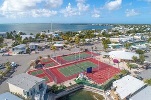 A coastal residential area with a tennis court complex, houses, and a marina. - Ocean Breeze Retreat w/ Dock - Keys Escape (Cudjoe Key)