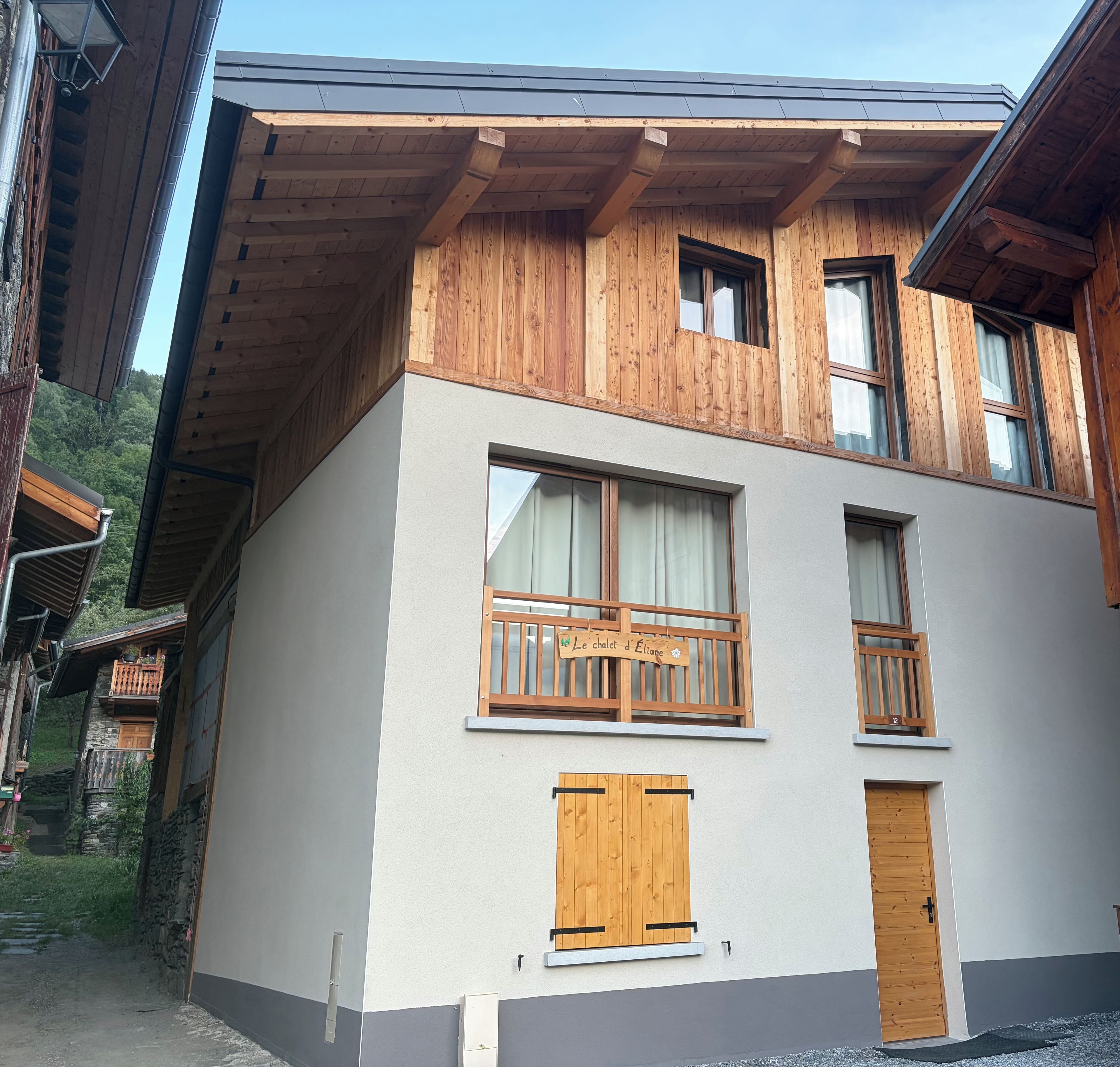 A two-story building with wooden balconies, a door, and a window.