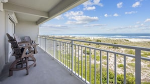 Ein Balkon mit Blick auf Strand und Meer.
