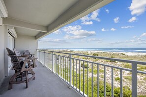 Ein Balkon mit Blick auf Strand und Meer.