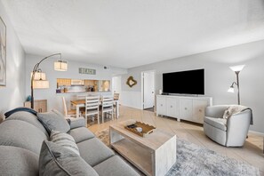 Ein modernes Wohnzimmer mit einer Couch, einem Couchtisch und einem Fernseher.