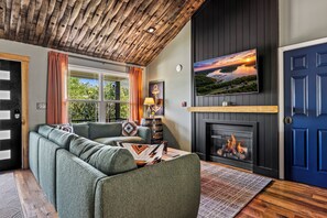 A living room with a sofa, fireplace, and a painting on the wall.