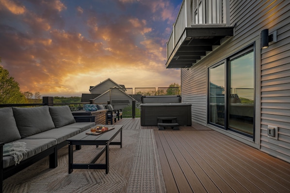 A deck with a sofa, table, and outdoor seating area.