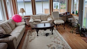 A living room with a sofa, armchair, coffee table, and a view of a lake through large windows. - Charming 1-bedroom available in the house  Burlington perfect for a cozy getaway (Burlington)