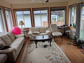 Un salon comprenant un canapé, un fauteuil, une table basse et offrant une vue sur un lac grâce à de grandes fenêtres.