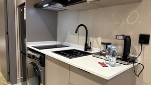 A modern kitchen with a built-in microwave, a coffee maker, and a dishwasher. - 309 Tara-jre 2bedroom at Jabal Al Lweibdeh (Amman)