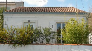 A white building with a tiled roof, a door, and a window. - Renovated shop in the heart of La Rochelle (La Rochelle)