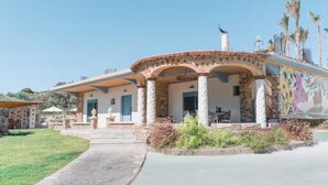 A two-story house with a patio, columns, and a mural. - Unique Villa Pietra: Priv. Pool Oasis, Top Beaches (ΡΟΔΟΣ)