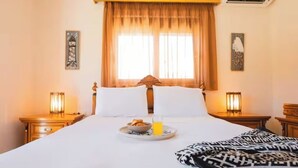 A hotel room with a bed, two bedside tables with lamps, a window with curtains, and a tray with breakfast. - Unique Villa Pietra: Priv. Pool Oasis, Top Beaches (ΡΟΔΟΣ)