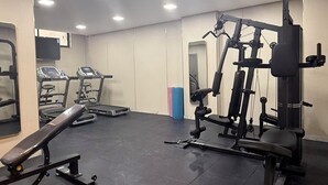 Een fitnessruimte met loopbanden, een bankdrukpers en gewichtstoestellen.