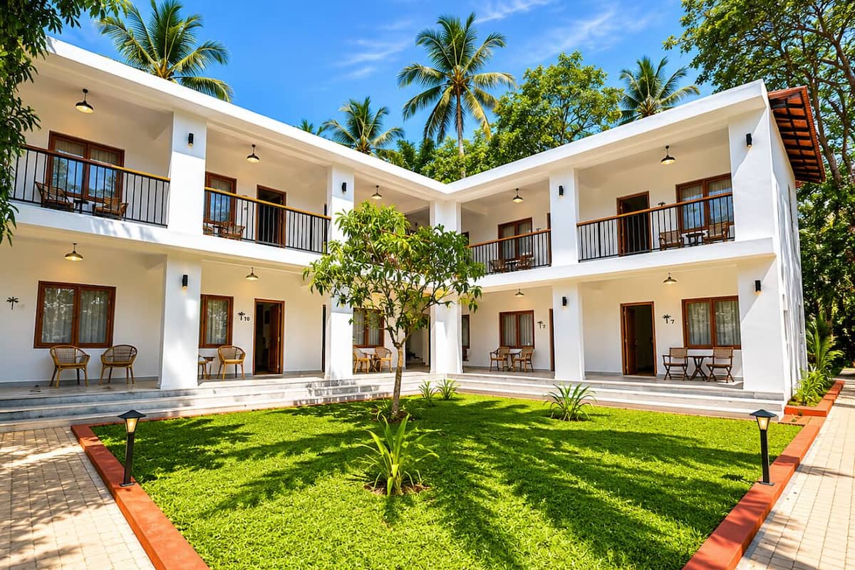 A multi-story hotel with balconies, outdoor seating, and a central lawn.
