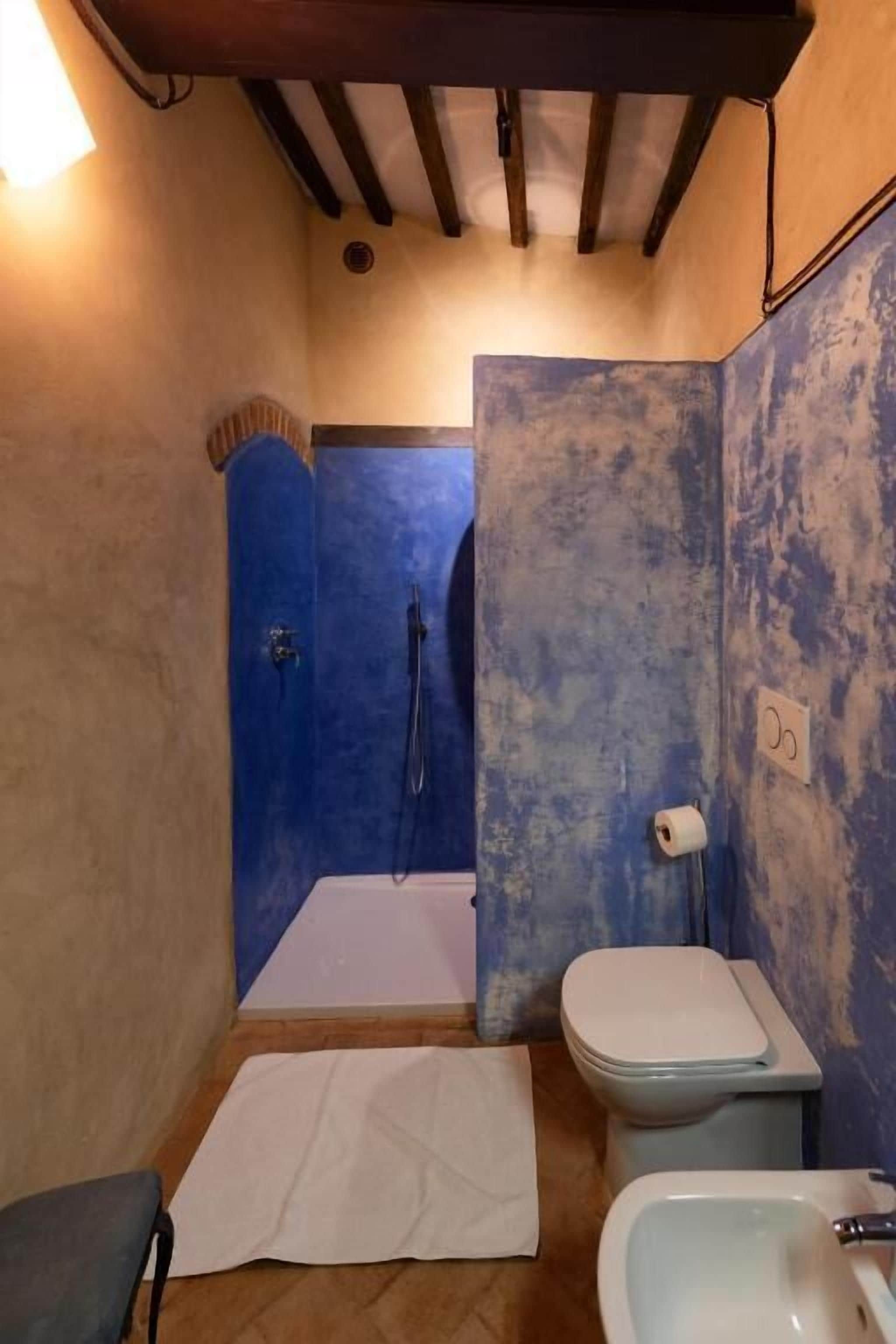 A small bathroom with a shower, toilet, and sink.