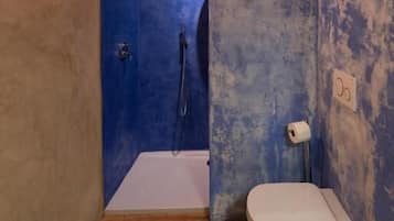 A small bathroom with a shower, toilet, and sink.
