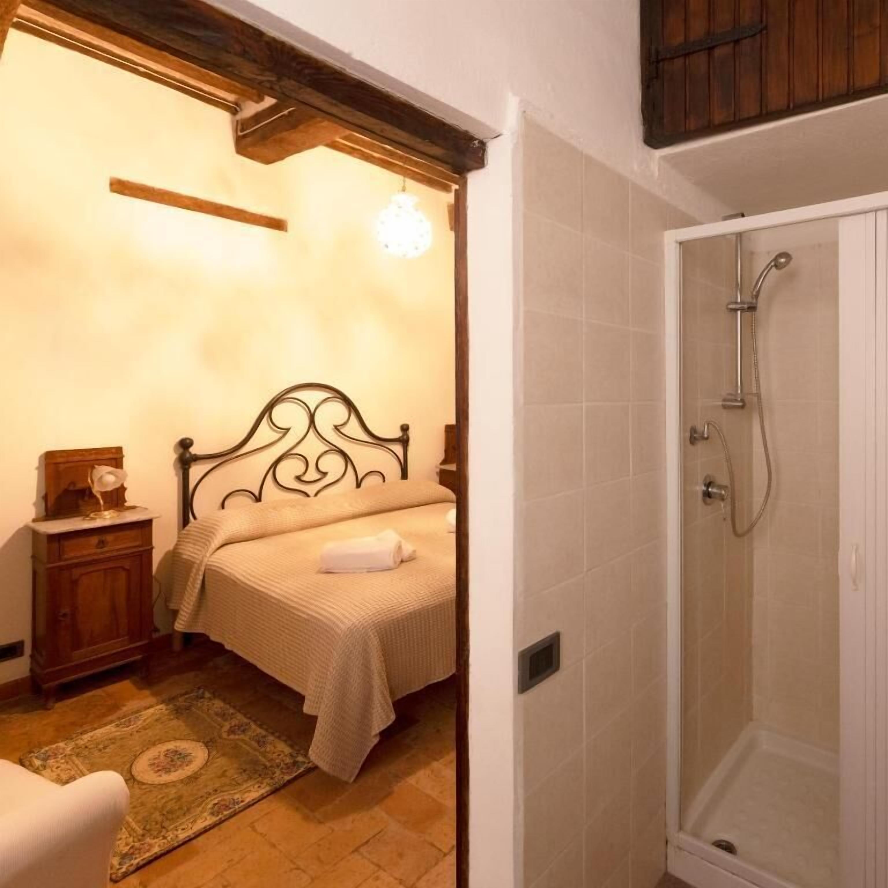 Ein Schlafzimmer mit Bett, Nachttisch und Dusche.