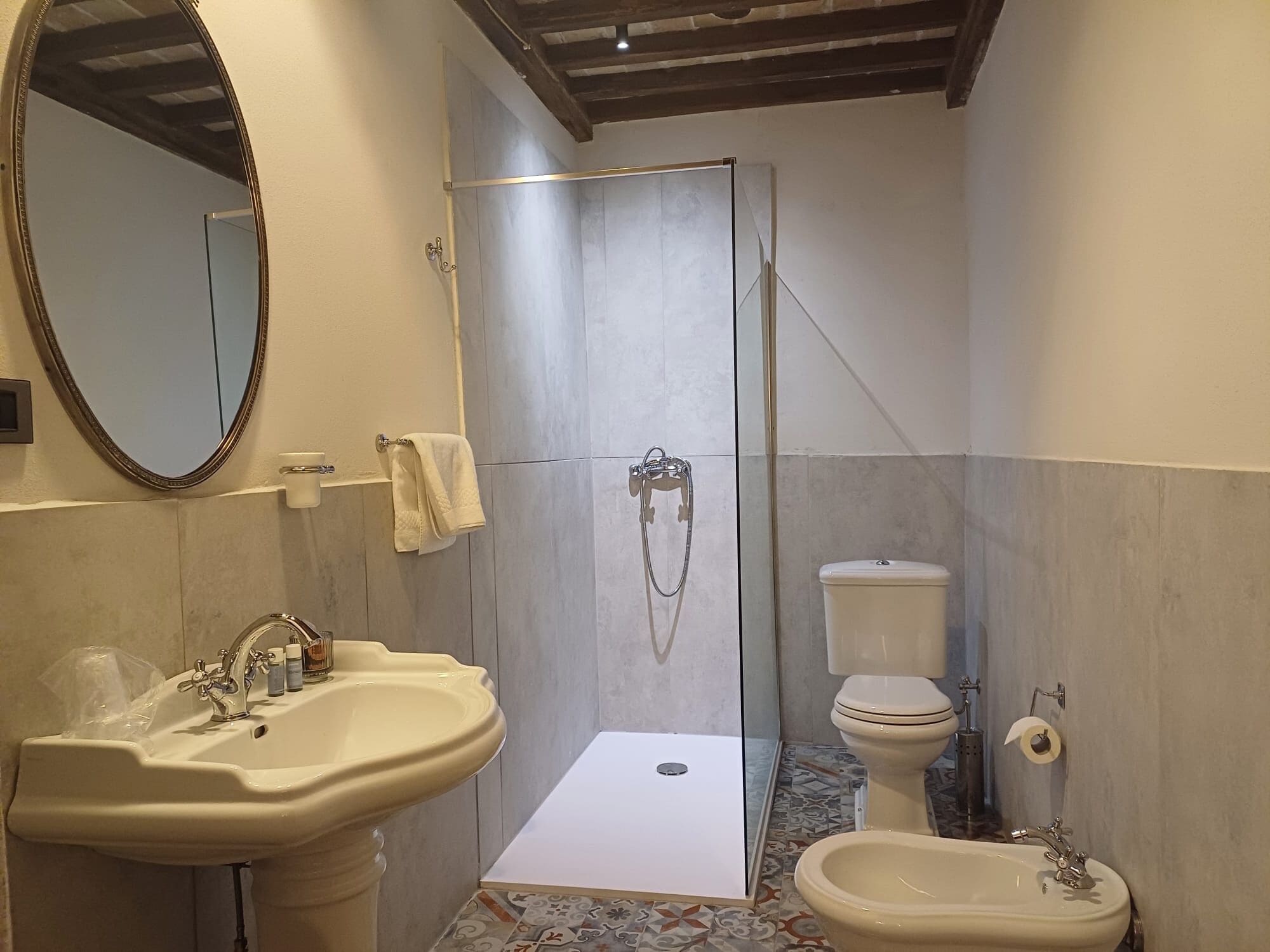 Ein Badezimmer mit Waschbecken, Bidet, Toilette und Duschbereich.