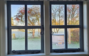A window with a view of trees and a wooden structure outside.