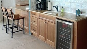 Una cocina con armarios de madera, cafetera, fregadero y lavavajillas.
