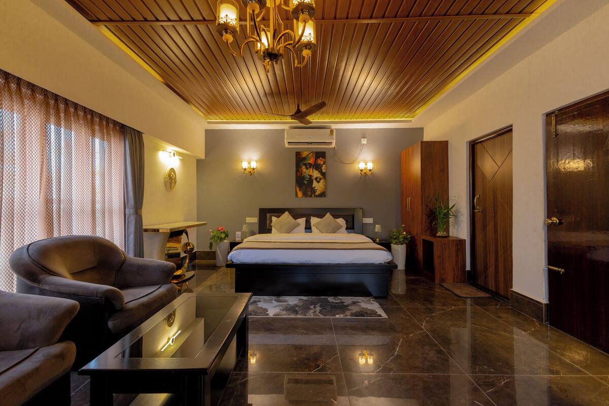 A modern bedroom with a large bed, a ceiling fan, and a nightstand with a lamp.