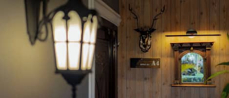 A wooden wall with a mounted deer head, a framed picture, and a sign reading 'ROOM NO. 14'.