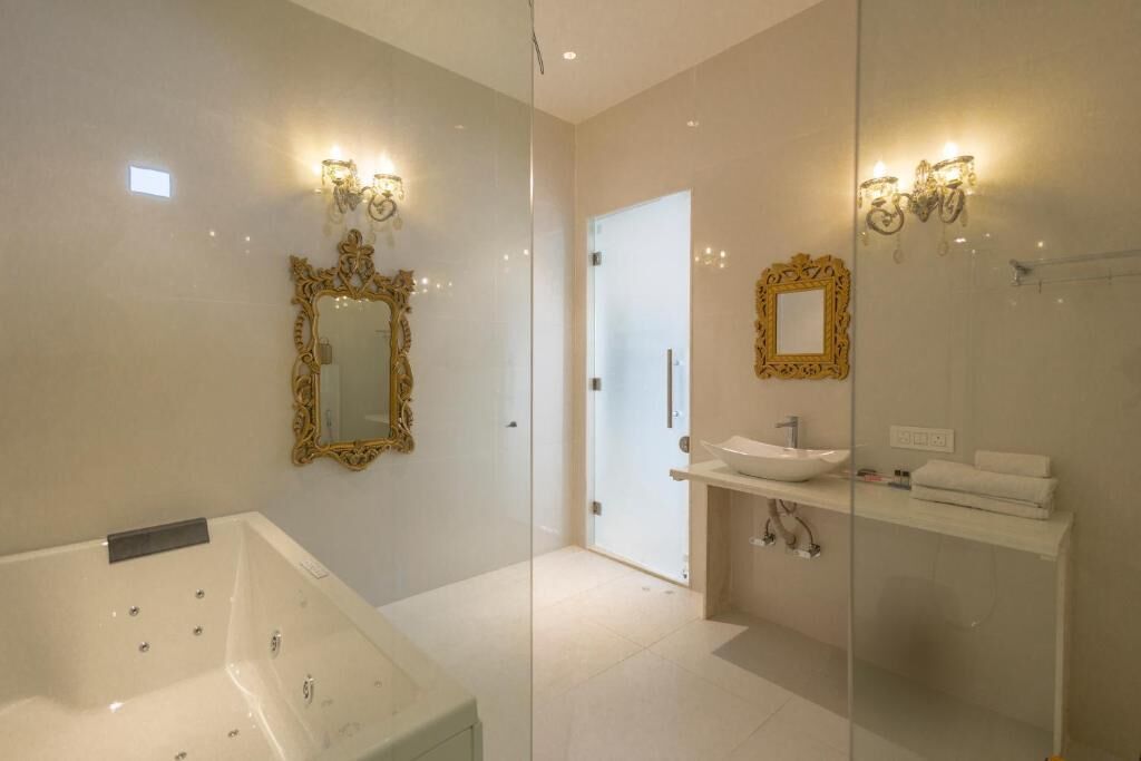 Un baño moderno con una bañera grande, un tocador con lavamanos y dos espejos montados en la pared.