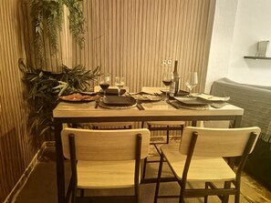 A dining table set with plates, glasses, and cutlery, surrounded by chairs. - Spacious apartment in city center (Granada)