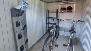 Una habitación compacta de estilo industrial con un soporte para bicicletas, una bicicleta y una unidad de ventilación.