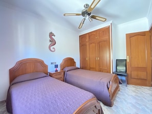 A bedroom with two beds, a wardrobe, a television, and a ceiling fan. - Mediterranean villa, private pool - max guests (Miami Playa)