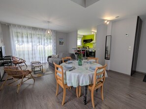 Ein Essbereich mit einem runden Tisch, gedeckt für sechs Personen, umgeben von Holzstühlen.