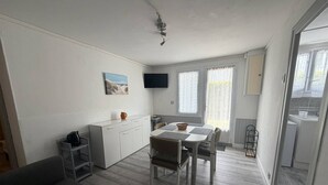 Ein kompakter Wohnbereich mit Küchenzeile, Essbereich und Sofa.