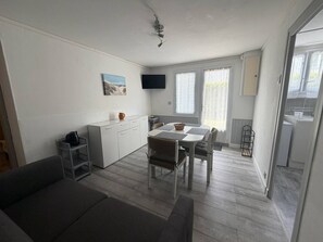 Ein kompakter Wohnbereich mit Küchenzeile, Essbereich und Sofa.