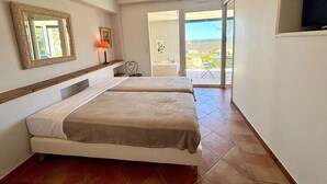 Une chambre d’hôtel avec deux lits, une salle de bain, une télévision et un balcon avec vue.