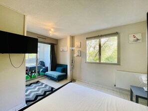 Ein Schlafzimmer mit Bett, Fenster mit Ausblick, Schreibtisch und Stuhl.