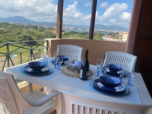 A table set outdoors with a scenic view, white chairs, and blue tableware. - MOYS APARTMENT SEA VIEW OLBIA (Olbia)