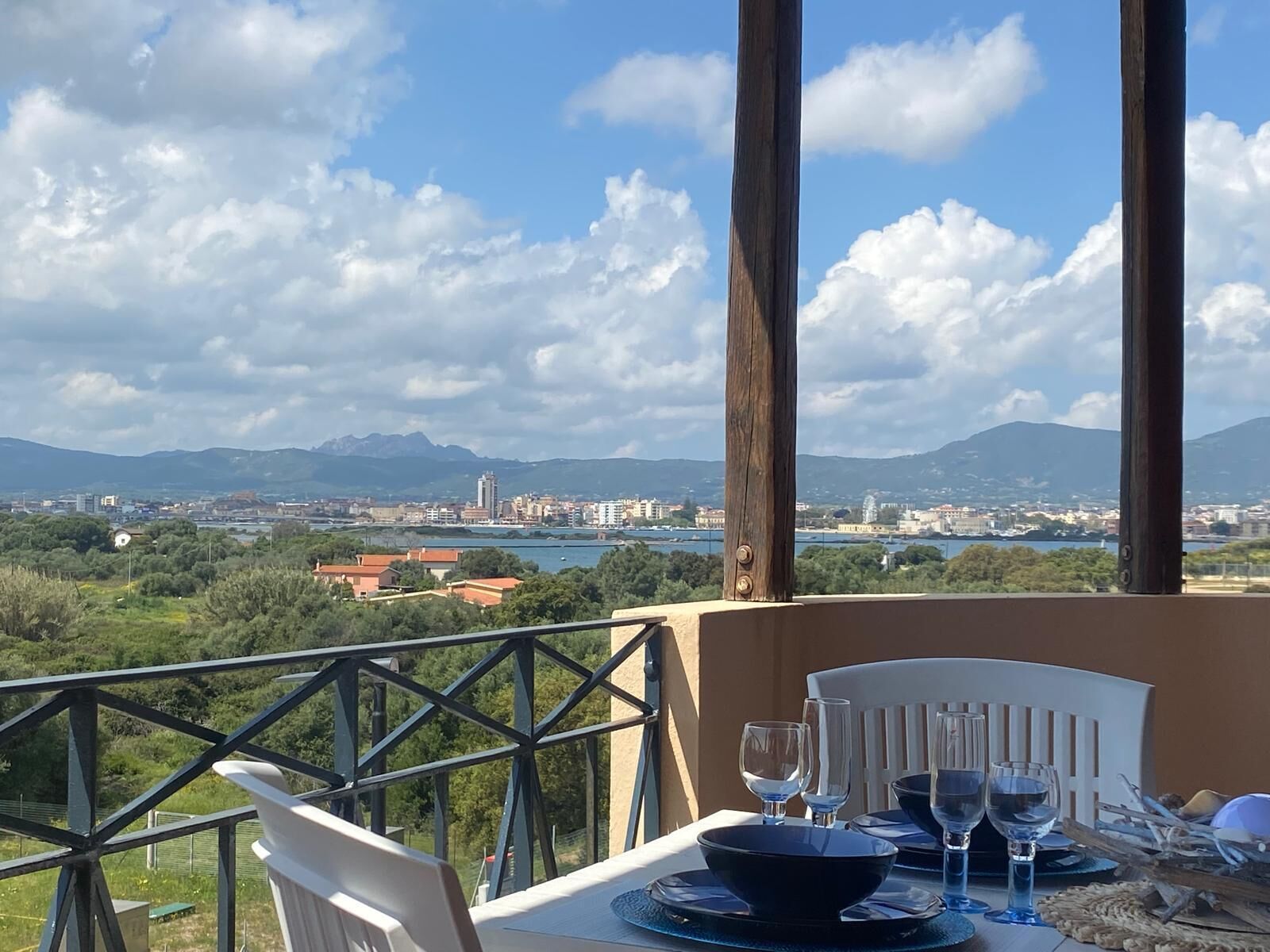 Mesa preparada para comer con vista a un paisaje urbano y montañas.