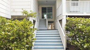 A staircase leading to a building entrance, flanked by greenery. - Quiet Family Home | Close to Beach, Restaurants, Boating | Daily Activity Deals (Orange Beach)