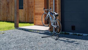 Un bâtiment en bois doté d’un balcon, d’un vélo et offrant une vue sur la montagne.