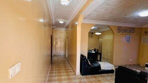 En hotellkorridor med ett mönstrat golv, en receptionsdisk och en säng.