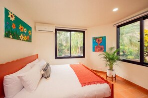 Une chambre à coucher avec un lit, une fenêtre et une plante en pot.
