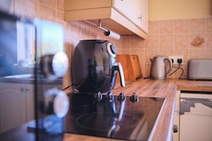 Una cucina con un fornello nero, un bollitore e un tostapane sul piano di lavoro.