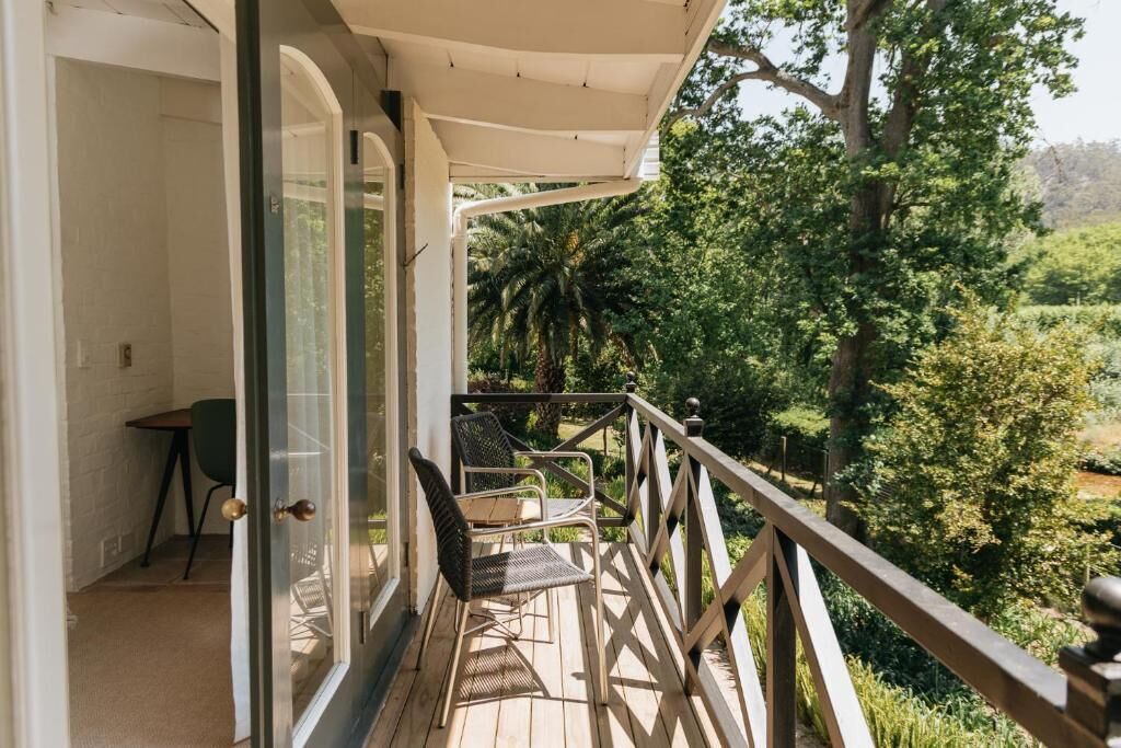 Un balcone con vista su un rigoglioso giardino e alberi.