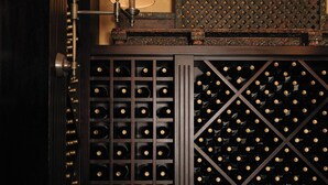 A wine cellar with a wooden wine rack and a lamp. - Klein Champagne Guesthouse and Cottages (Franschhoek)