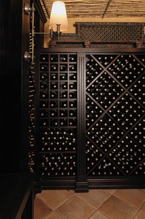 Una bodega con una estantería de madera para vinos y una lámpara.