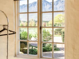 Una ventana con vistas a un paisaje montañoso y vegetación.