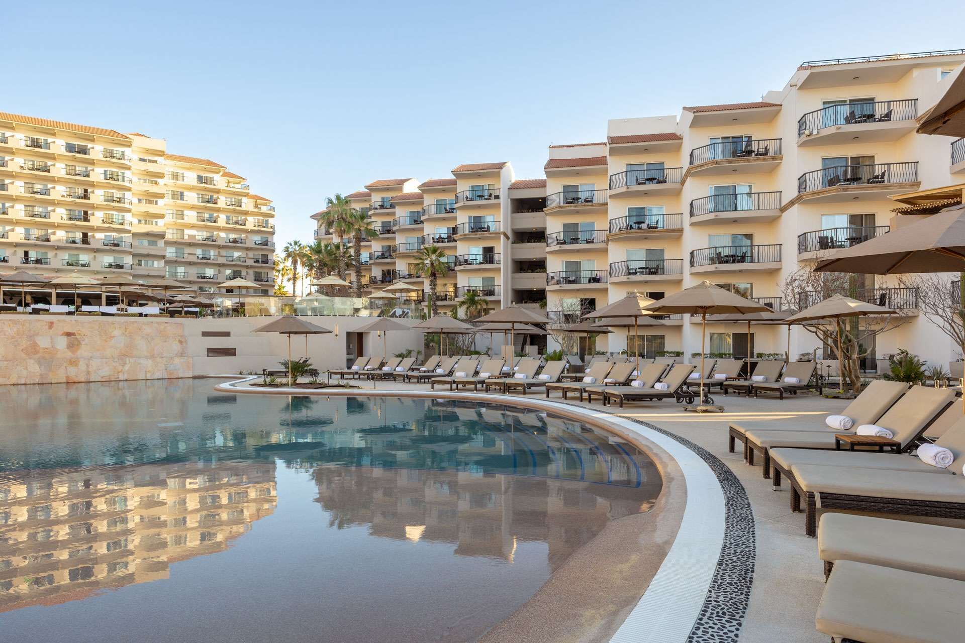 Ein Resort mit großem Pool, mehreren Balkonen und Liegestühlen.
