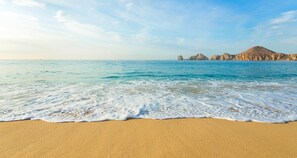 A beach with clear blue water and a sandy shore. - Cabo San Lucas Beach Luxury One Bedroom Villa del Palmar Resort & Spa (Cabo San Lucas)