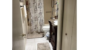 A bathroom with a shower curtain, a toilet, a sink with a mirror, and a towel rack. - Cancer patients that need peace, quiet, support & proximity to treatment plans. (Cave Creek)