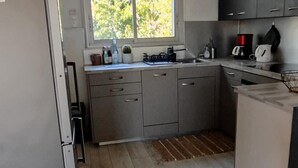 Eine moderne Küche mit Kühlschrank, Spüle und Fenster.