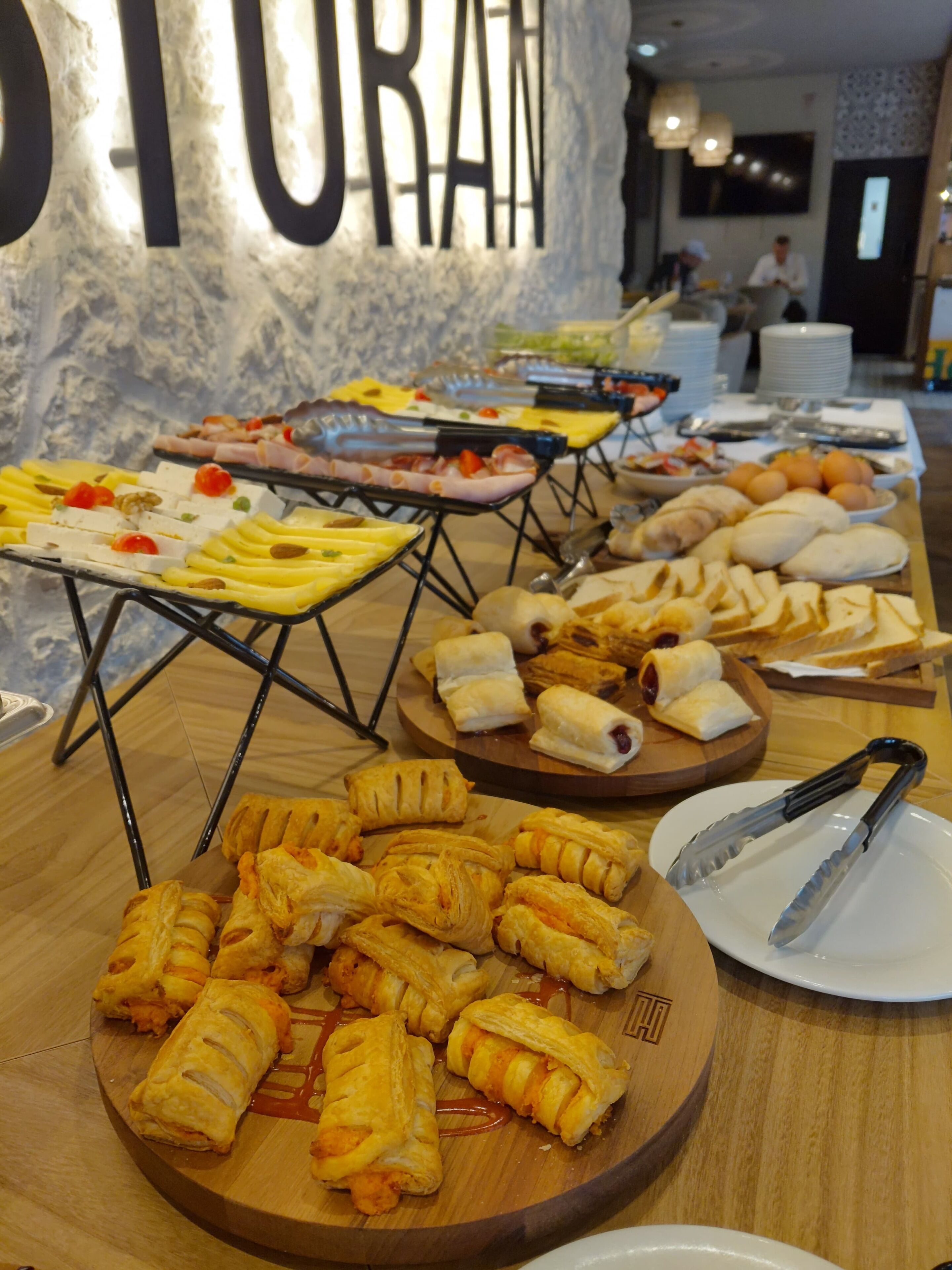 Un buffet proposant une variété de plats, notamment des pâtisseries, des fruits et des viandes.