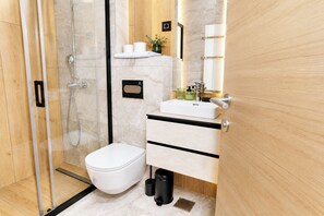 Deluxe appartement, balkon, uitzicht op stad | Badkamer | Een douche, handdoeken, zeep, shampoo